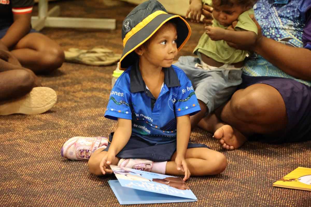 Young student reading a book on the floor