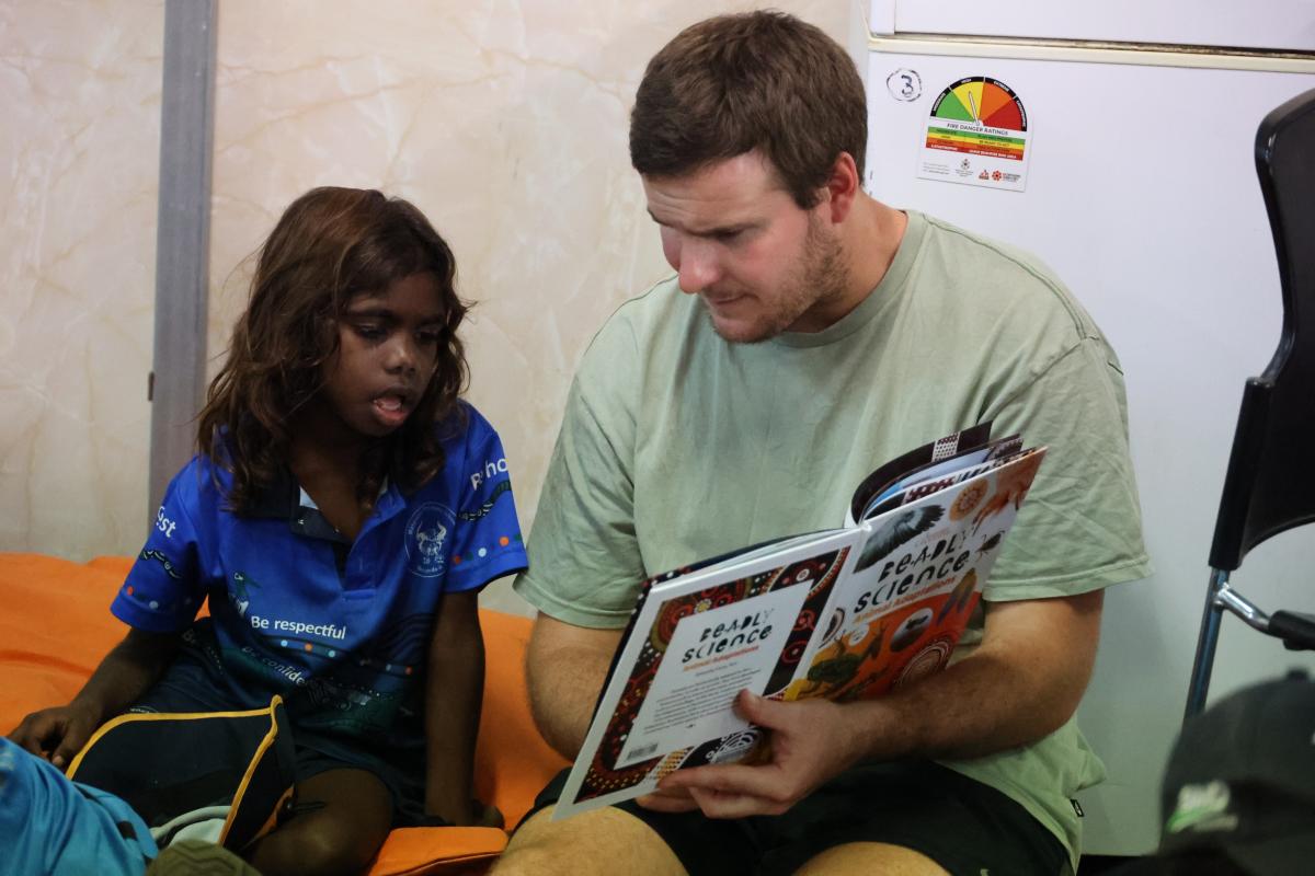 Teacher and student reading a book