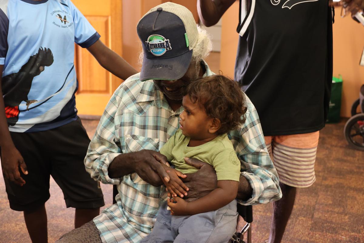 Grandparent with grandchild sitting on his knee