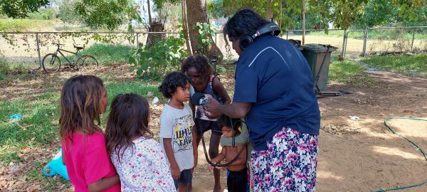 Children being recorded outside on voice recorder