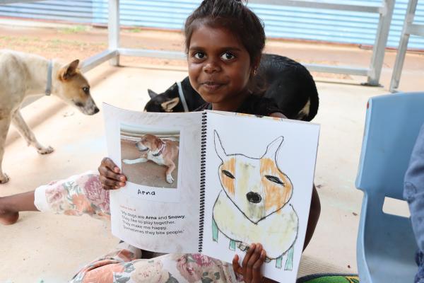 Young girl holding up a book