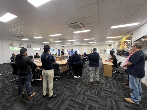 Multiple people standing in a meeting 