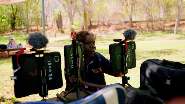 A woman training on an iPad with a microphone at the Katherine gorge