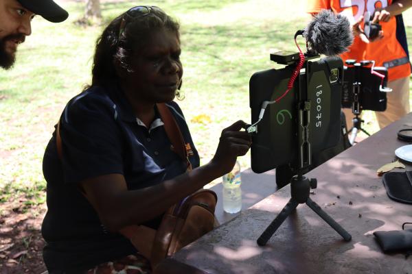 A woman training on an iPad with a microphone at the Katherine gorge
